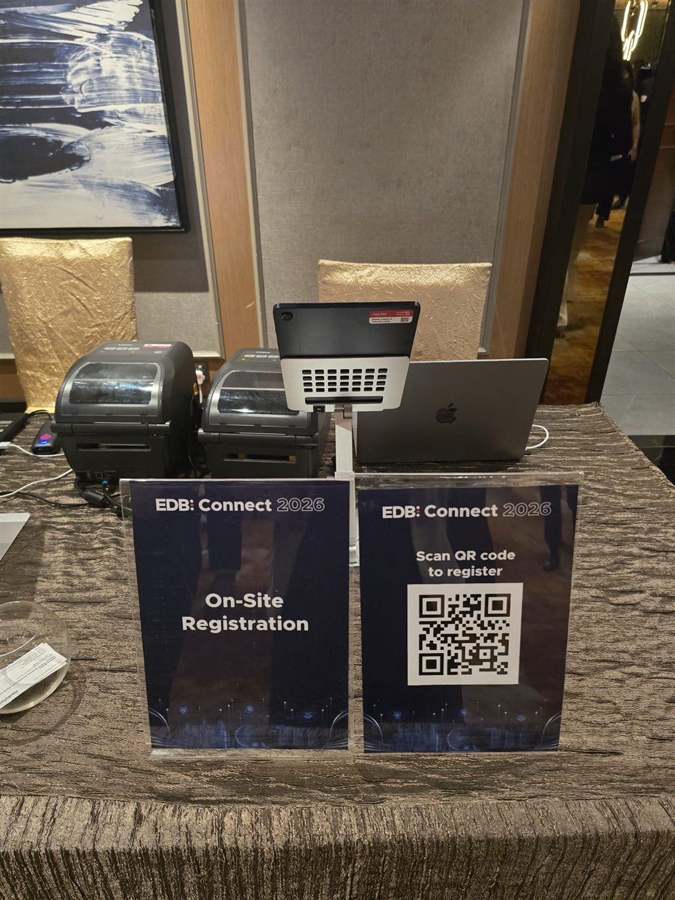 The on-site registration counter with badge printers at EDB Connect 2026