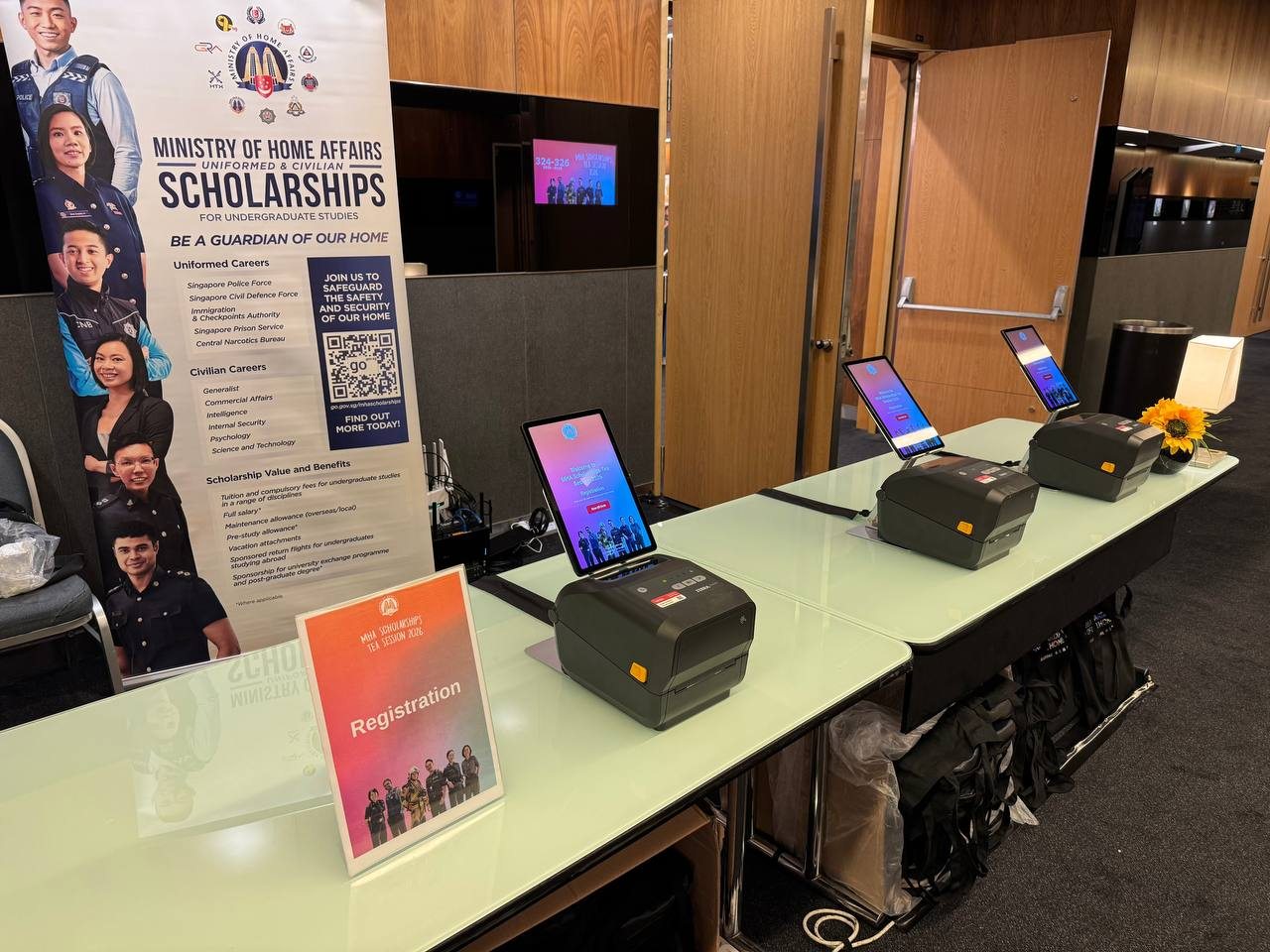 The registration counter with tablet check-in and badge printers at the MHA Scholarships Tea Session 2026